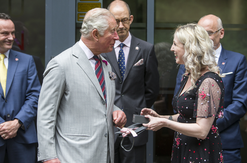 HRH Prince Charles being gifted with a piece of jewellery from a business owner that went through the Princes Trust programme